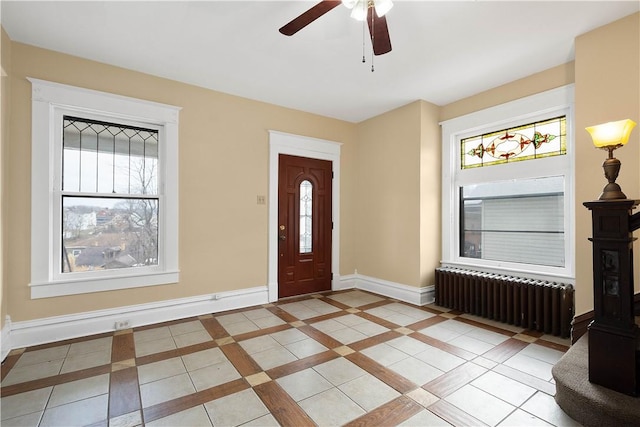 foyer featuring ceiling fan, a healthy amount of sunlight, radiator, and light tile patterned floors