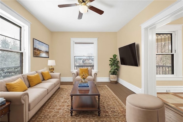 living room with ceiling fan, light wood-type flooring, and a wealth of natural light