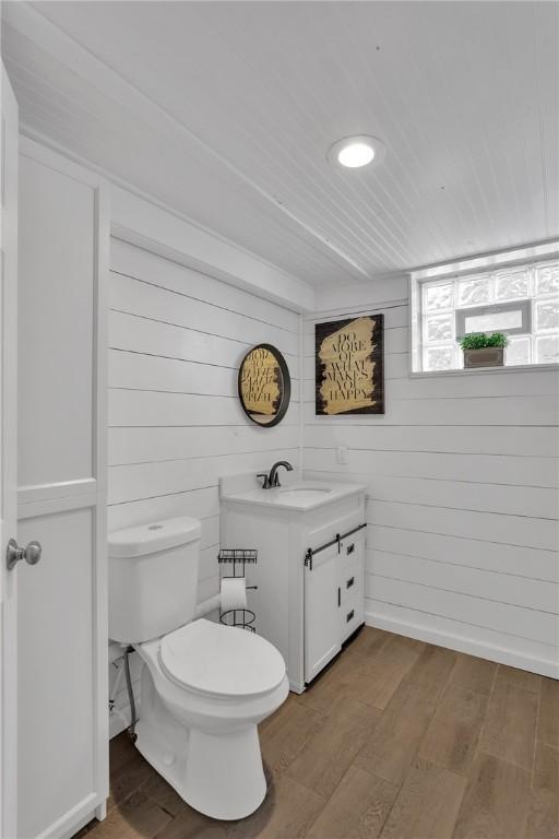 bathroom with hardwood / wood-style flooring, vanity, and toilet