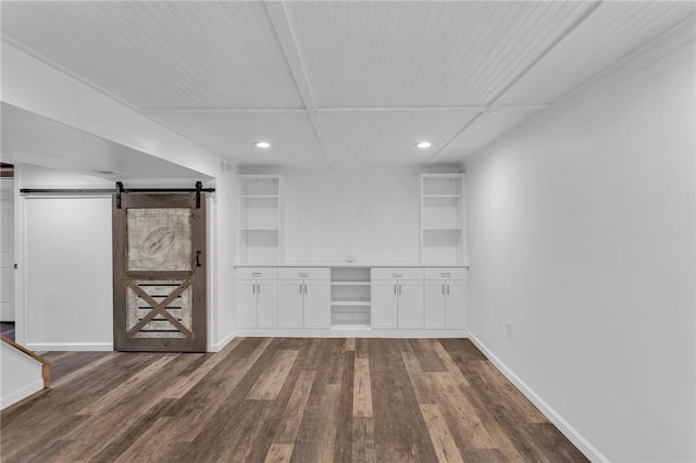 basement with a barn door and dark hardwood / wood-style floors