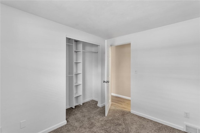 unfurnished bedroom with carpet flooring and a closet