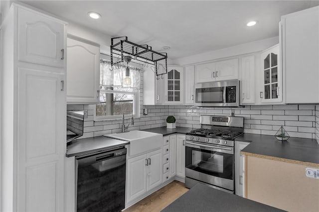 kitchen featuring backsplash, appliances with stainless steel finishes, sink, and white cabinets