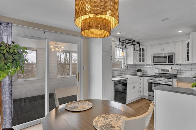 dining room with sink, a chandelier, and light hardwood / wood-style floors