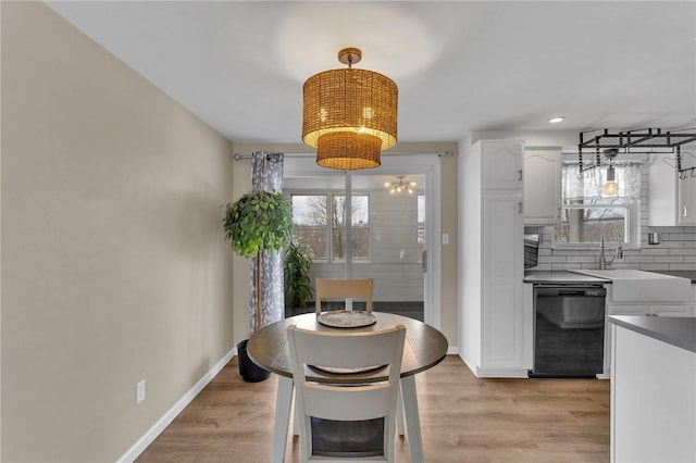 dining area featuring sink, a chandelier, and light hardwood / wood-style floors