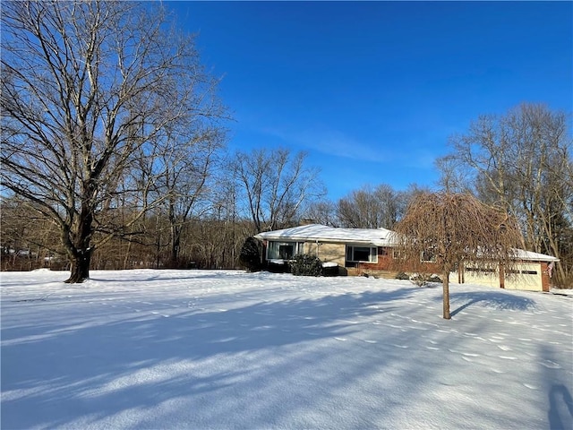 yard covered in snow featuring a garage