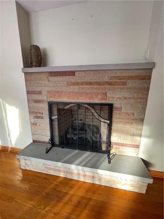 interior details featuring a fireplace and wood-type flooring