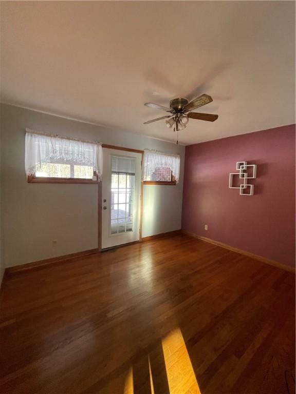 unfurnished room with dark hardwood / wood-style flooring, ceiling fan, and a healthy amount of sunlight