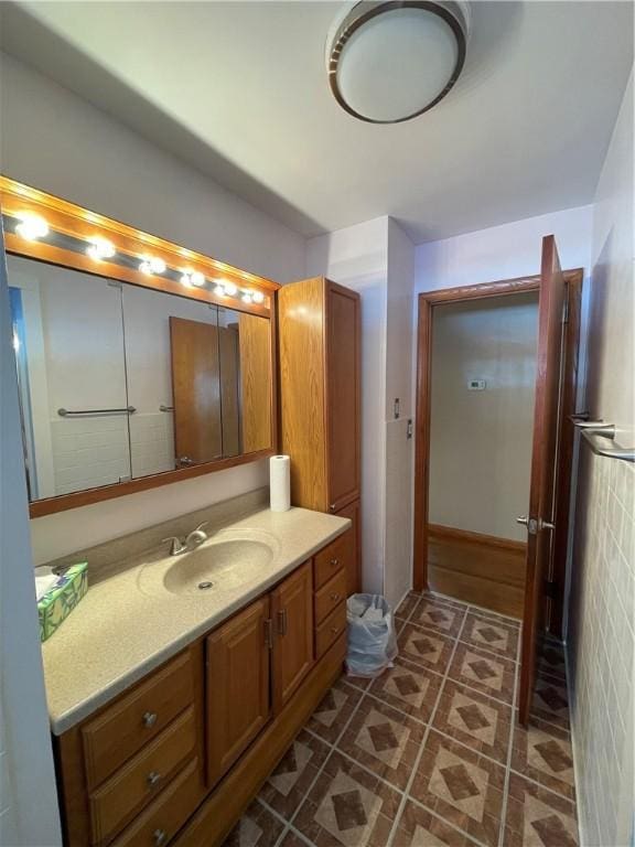 bathroom with tile patterned floors, vanity, and tile walls