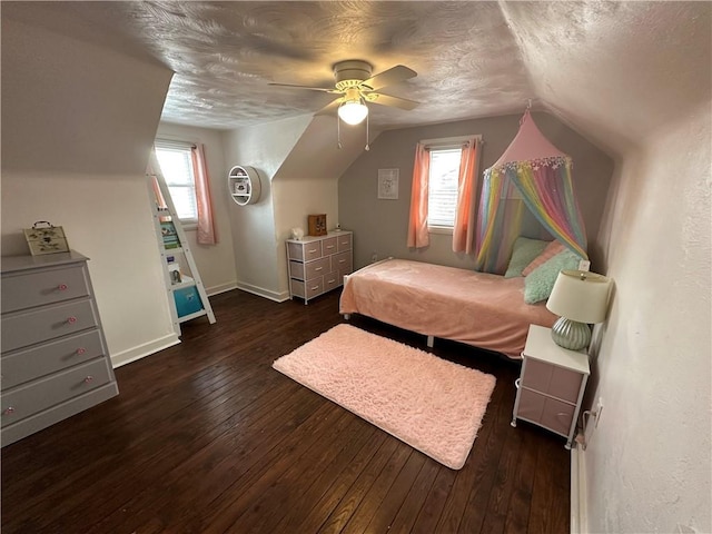 bedroom with multiple windows, dark wood-type flooring, a textured ceiling, and vaulted ceiling