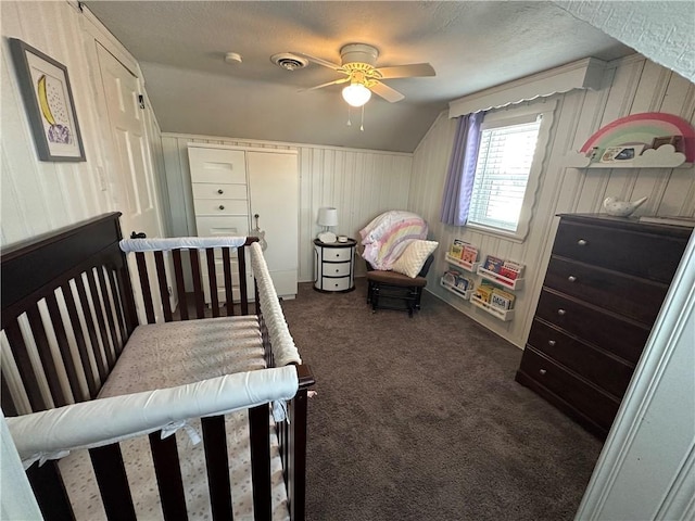 carpeted bedroom featuring ceiling fan, lofted ceiling, and a textured ceiling