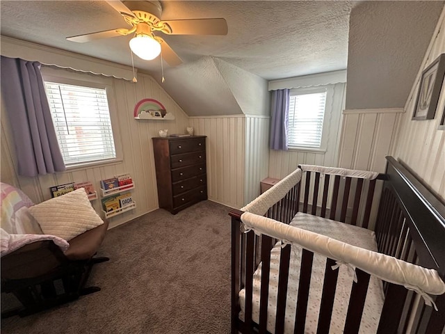 carpeted bedroom featuring ceiling fan, lofted ceiling, and a textured ceiling