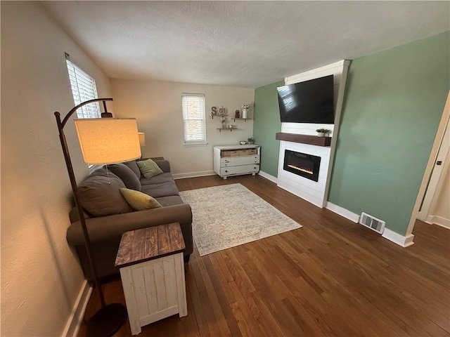 living room with dark hardwood / wood-style flooring and a textured ceiling