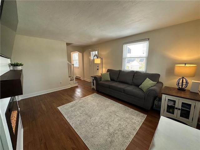 living room with dark hardwood / wood-style floors and a textured ceiling