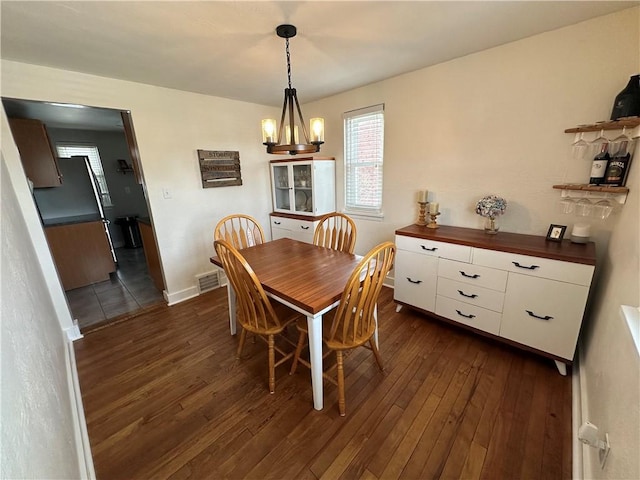 dining space featuring a notable chandelier and dark wood-type flooring