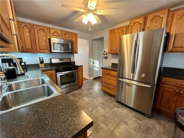 kitchen featuring appliances with stainless steel finishes, sink, and ceiling fan