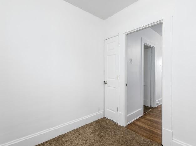 spare room featuring dark colored carpet