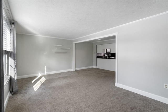 carpeted empty room with ornamental molding and a textured ceiling