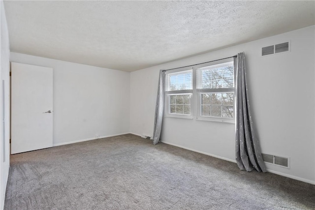 empty room with carpet flooring and a textured ceiling