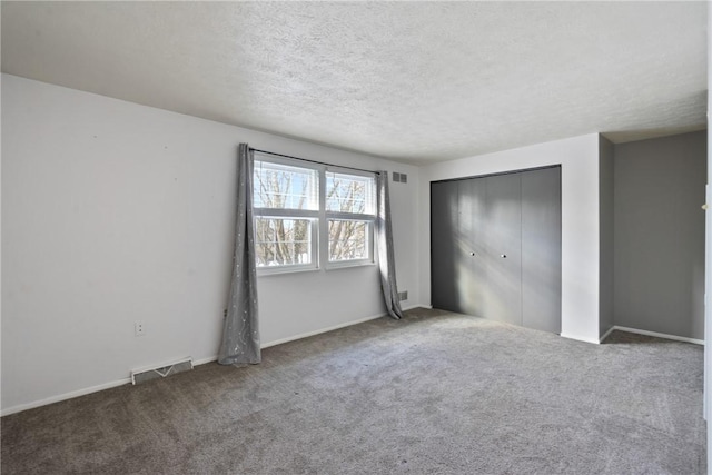 unfurnished bedroom featuring a closet, carpet, and a textured ceiling