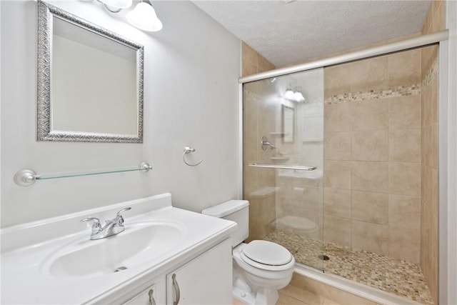 bathroom with vanity, toilet, an enclosed shower, and a textured ceiling