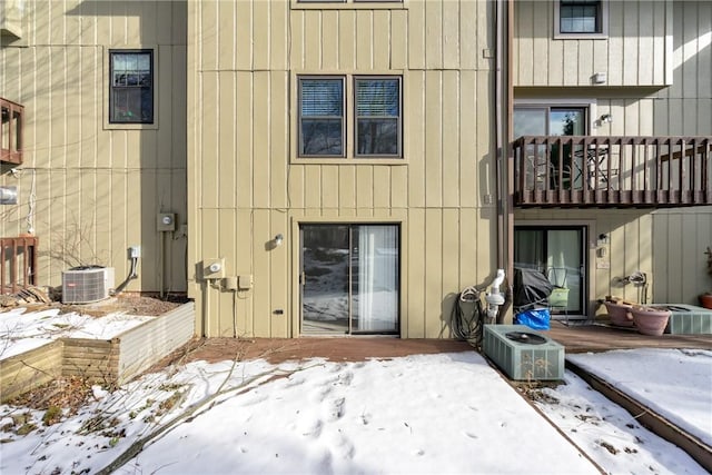 snow covered back of property with cooling unit