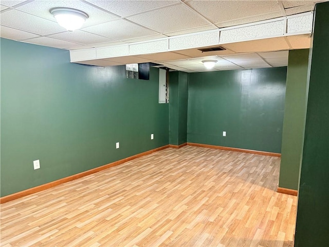 basement featuring a drop ceiling and wood-type flooring