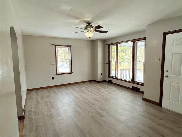 spare room with ceiling fan, a wealth of natural light, and light wood-type flooring