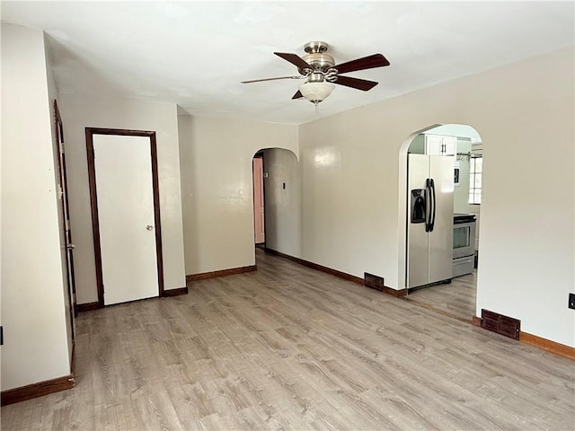 empty room with ceiling fan and light hardwood / wood-style flooring