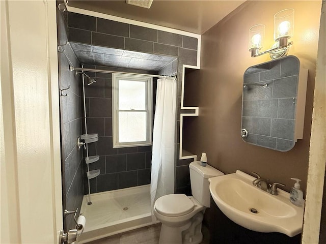 bathroom featuring sink, curtained shower, and toilet