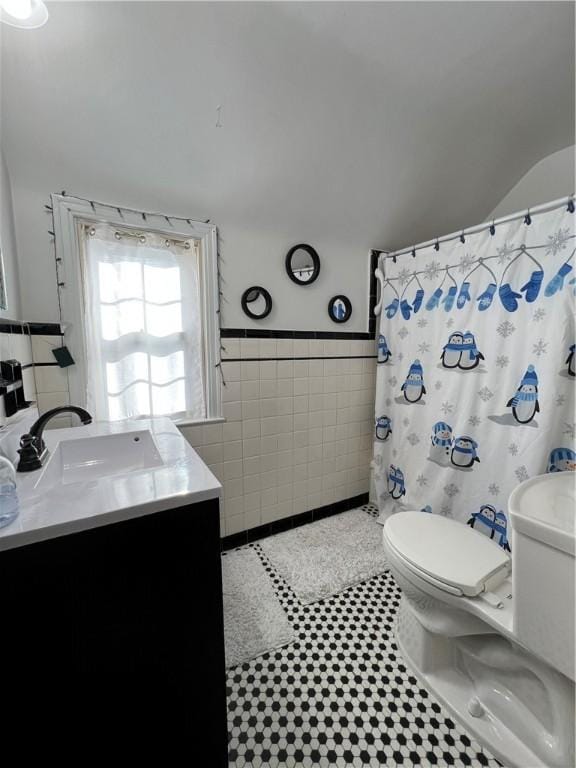 bathroom featuring tile patterned flooring, tile walls, a shower with shower curtain, vanity, and toilet