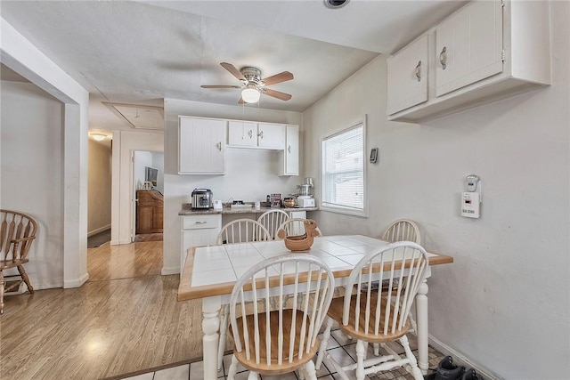 dining space with ceiling fan and light hardwood / wood-style flooring