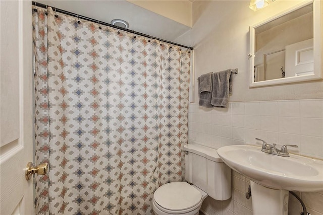 bathroom with tile walls, sink, and toilet