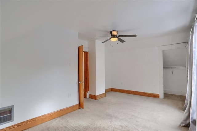 unfurnished bedroom with light colored carpet, a closet, and ceiling fan