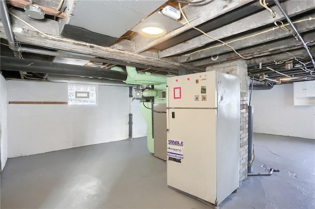 basement featuring white refrigerator and fridge