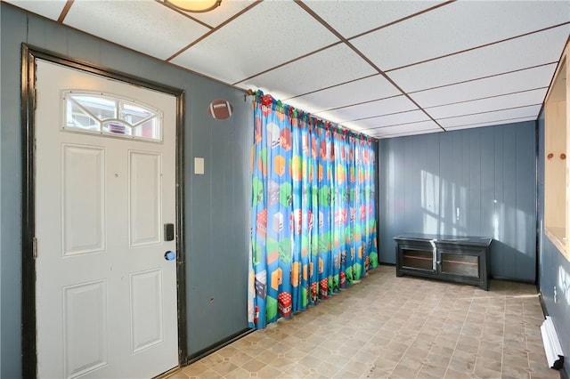 entrance foyer featuring a drop ceiling and wood walls