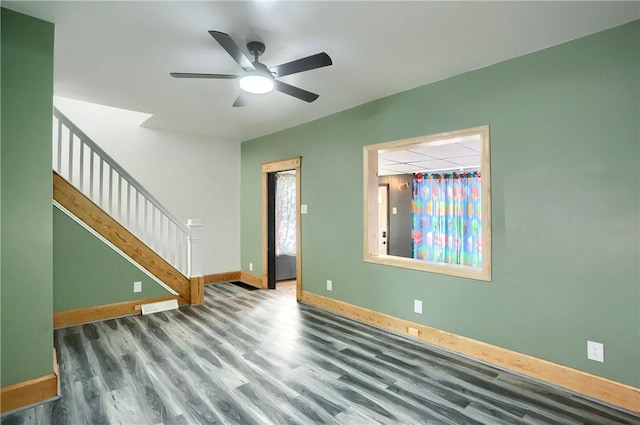 unfurnished room featuring dark hardwood / wood-style flooring, ceiling fan, and a drop ceiling