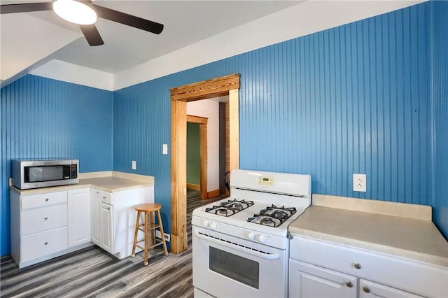 kitchen with white cabinetry, dark wood-type flooring, ceiling fan, and gas range gas stove