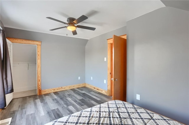 unfurnished bedroom featuring vaulted ceiling, hardwood / wood-style floors, ceiling fan, and a closet