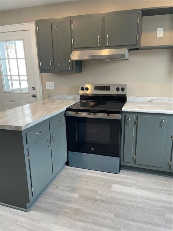 kitchen featuring stainless steel electric range oven, a peninsula, light countertops, light wood-style floors, and under cabinet range hood