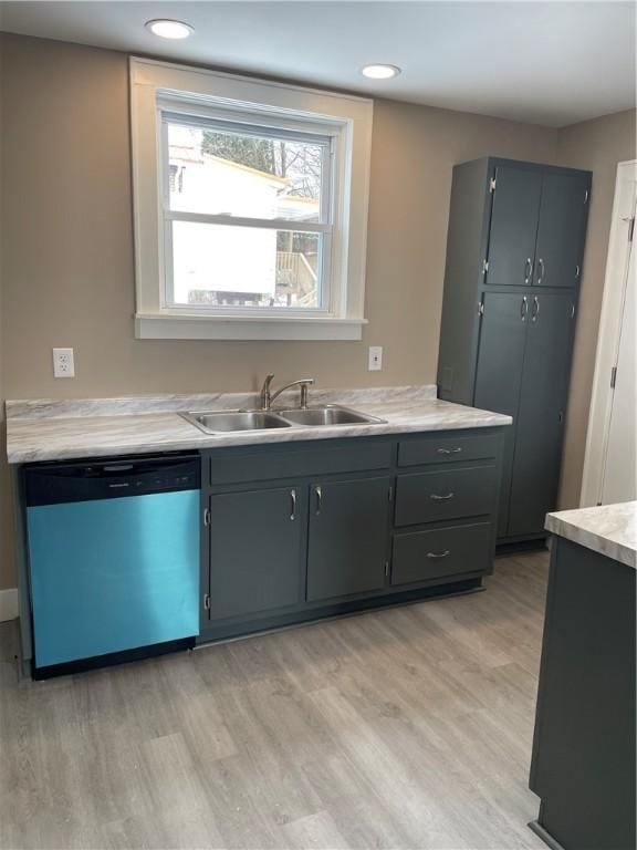 kitchen with light wood finished floors, dishwasher, light countertops, gray cabinets, and a sink