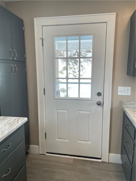 doorway to outside with baseboards and wood finished floors