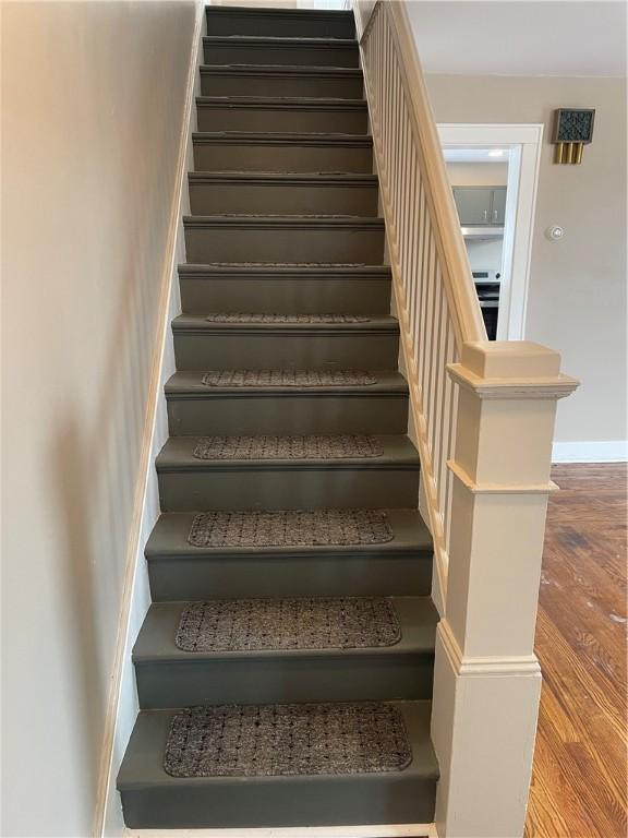 stairway featuring baseboards and wood finished floors