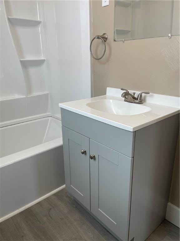 bathroom featuring bathtub / shower combination, wood finished floors, and vanity