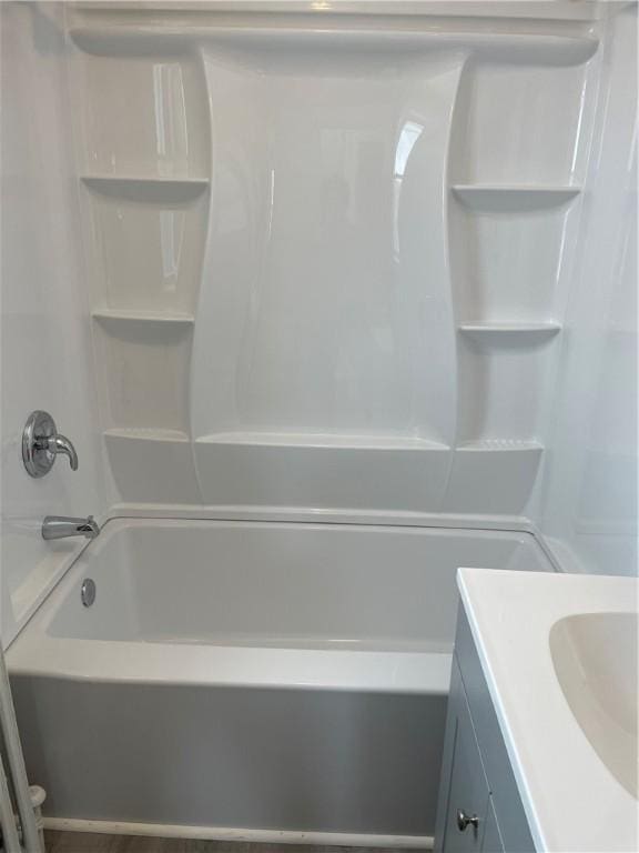 bathroom featuring washtub / shower combination and vanity