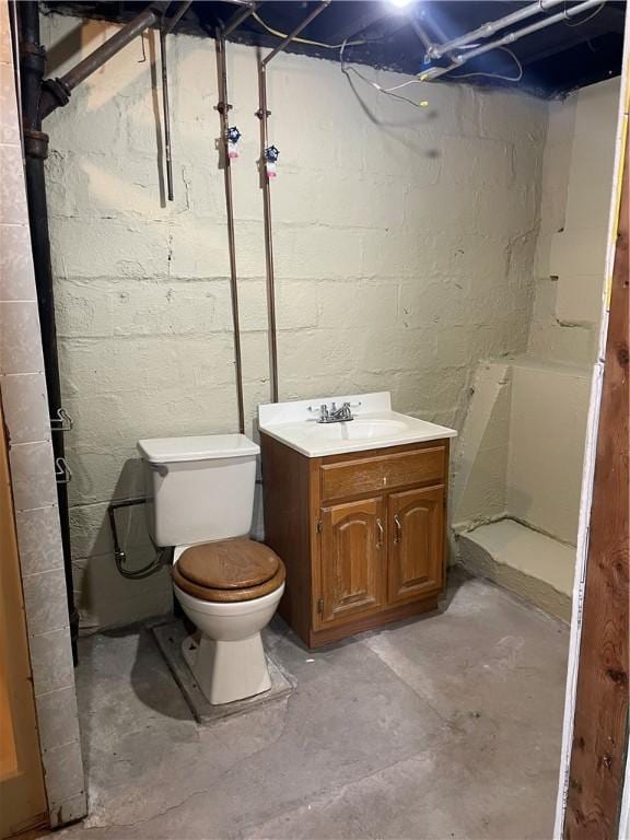 full bathroom with vanity, toilet, a shower, and concrete floors