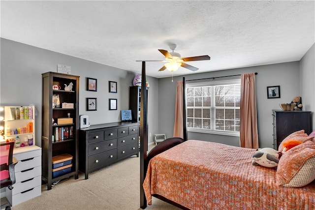 carpeted bedroom featuring ceiling fan and a textured ceiling