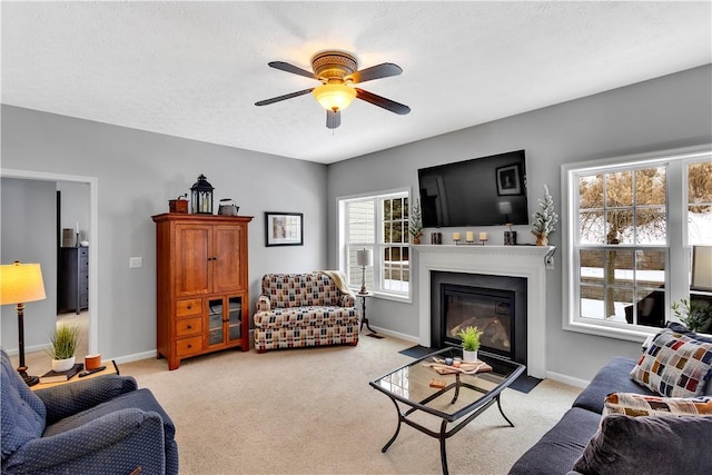 carpeted living room with ceiling fan and a textured ceiling