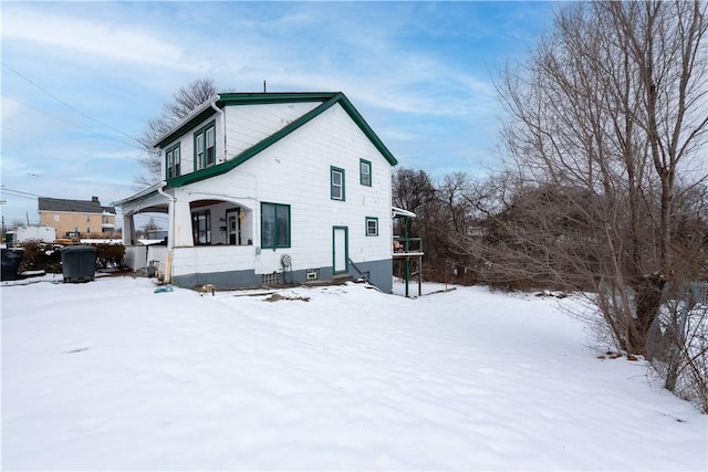 view of snow covered rear of property