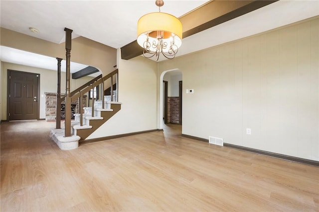 interior space with an inviting chandelier, hardwood / wood-style flooring, and beamed ceiling