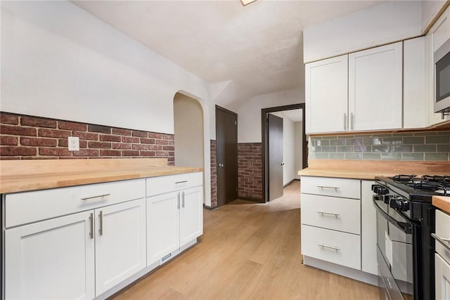 kitchen with white cabinetry, wooden counters, light hardwood / wood-style floors, and black range with gas cooktop